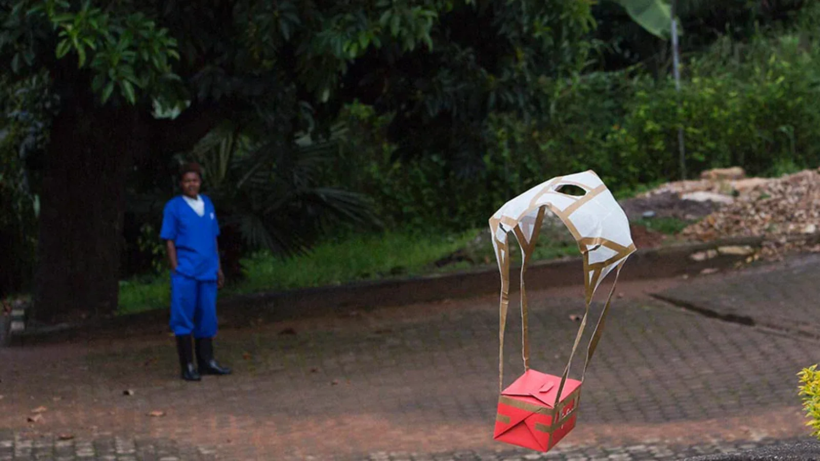 A parachuted Zipline package containing blood products descends near a health facility in Rwanda.