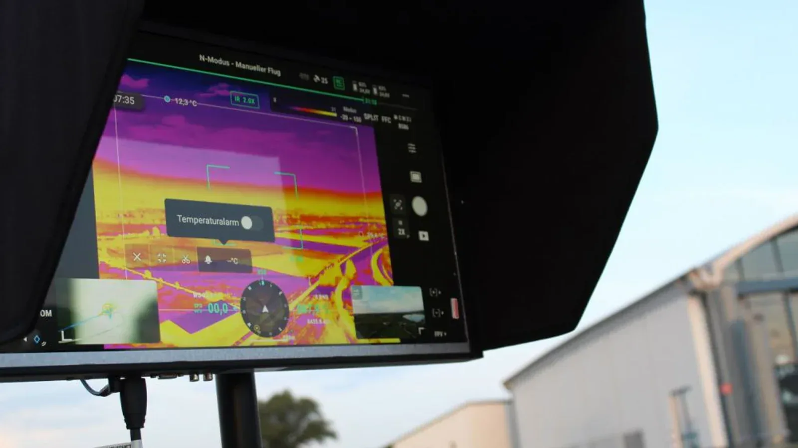 A Landshut fire-service monitor shows a live thermal view from the drone system.