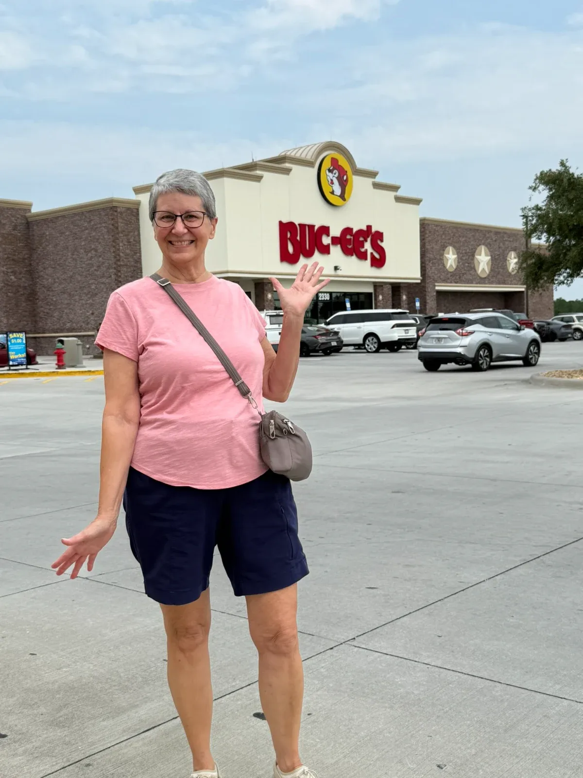 Colin's mom smiling and waving outside a Buc-ee's stop during the road trip.