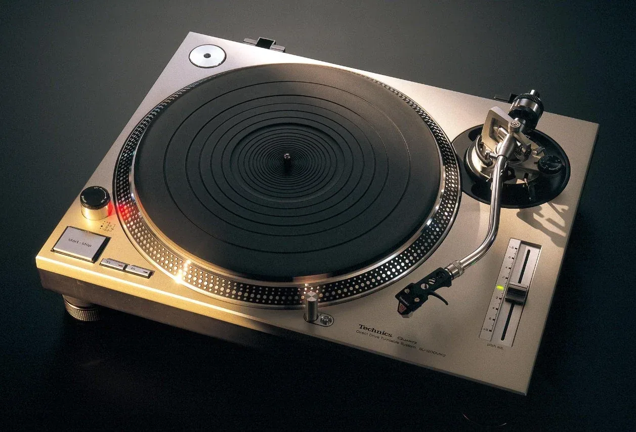 Official historical photograph of the silver 1979 Technics SL-1200MK2 showing its quartz controls, vertical pitch fader, strobe platter and S-shaped tonearm.
