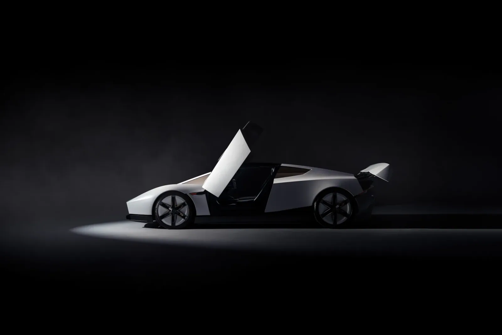 Side-profile studio view with the doors raised and rear wing deployed.