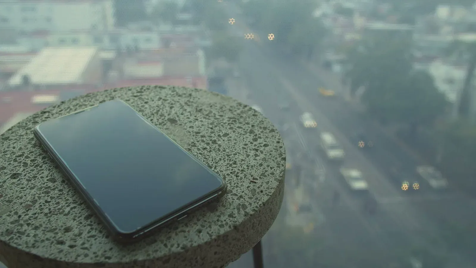 A silent smartphone resting on a small table beside a window
