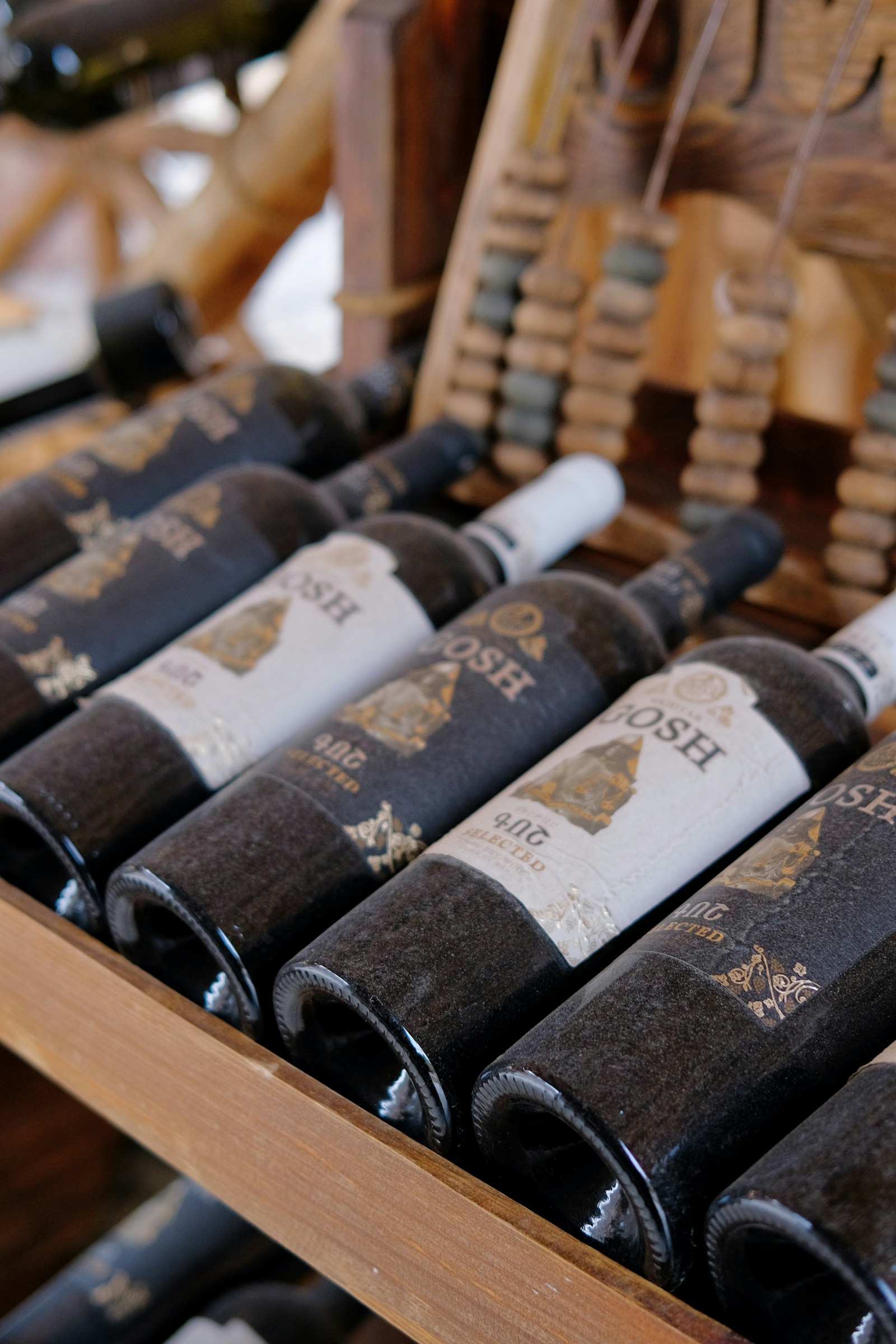 Wine bottles resting side by side in a wooden rack