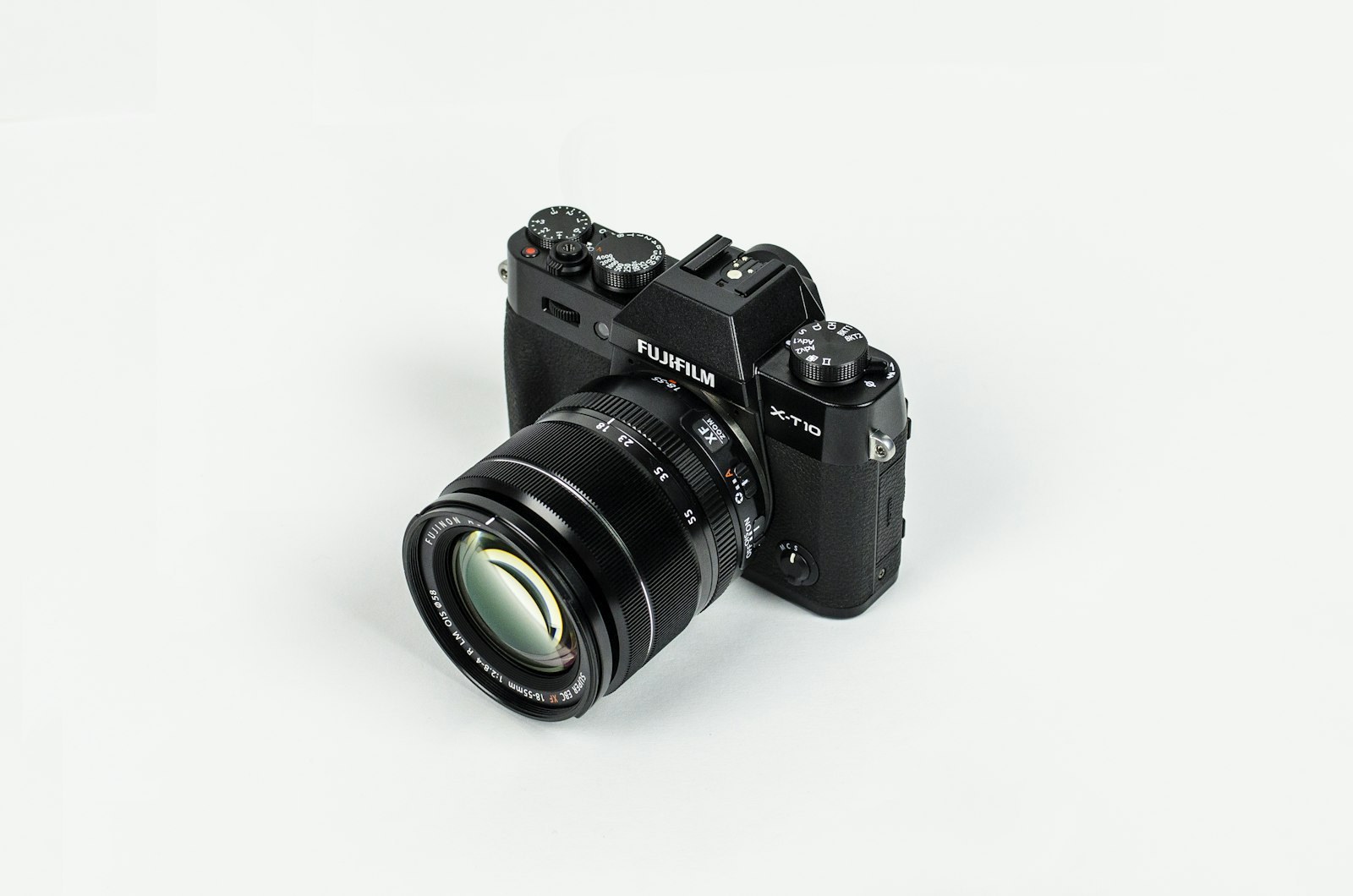 A black mirrorless camera with a zoom lens on a white background