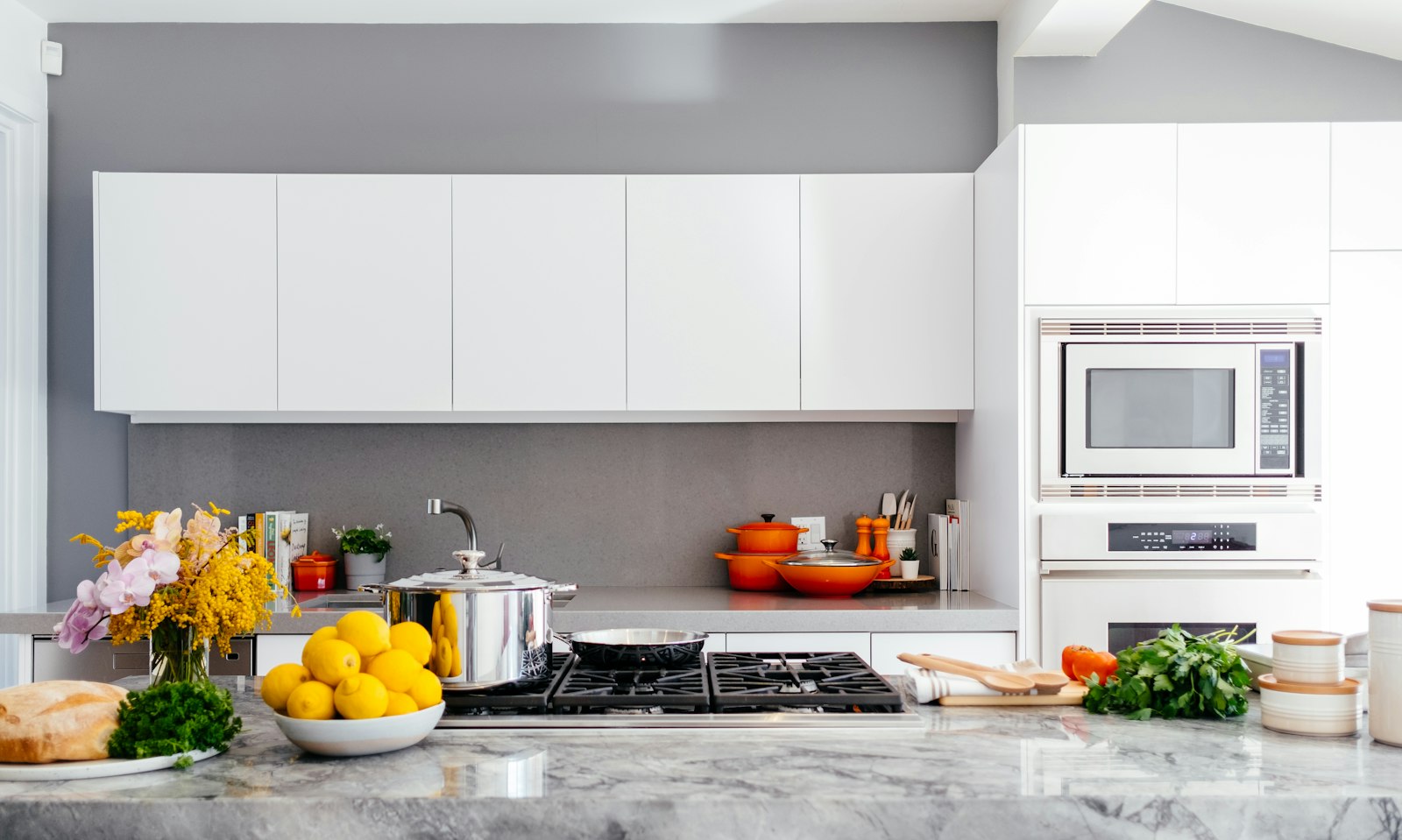 A bright kitchen island with cookware, utensils, and fresh produce