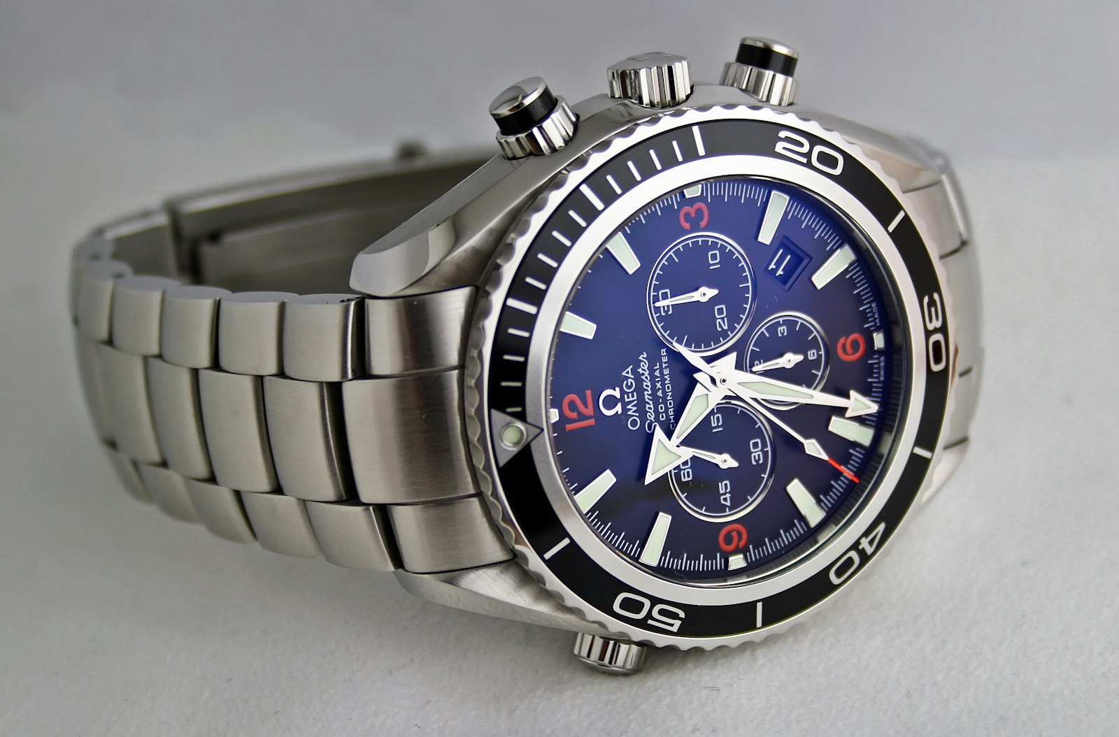 A steel chronograph wristwatch with a blue dial