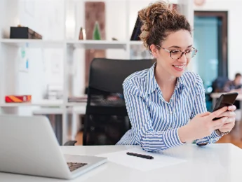 Foto di una ragazza in camicia azzura che lavora in smart working dall’ufficio di cassa