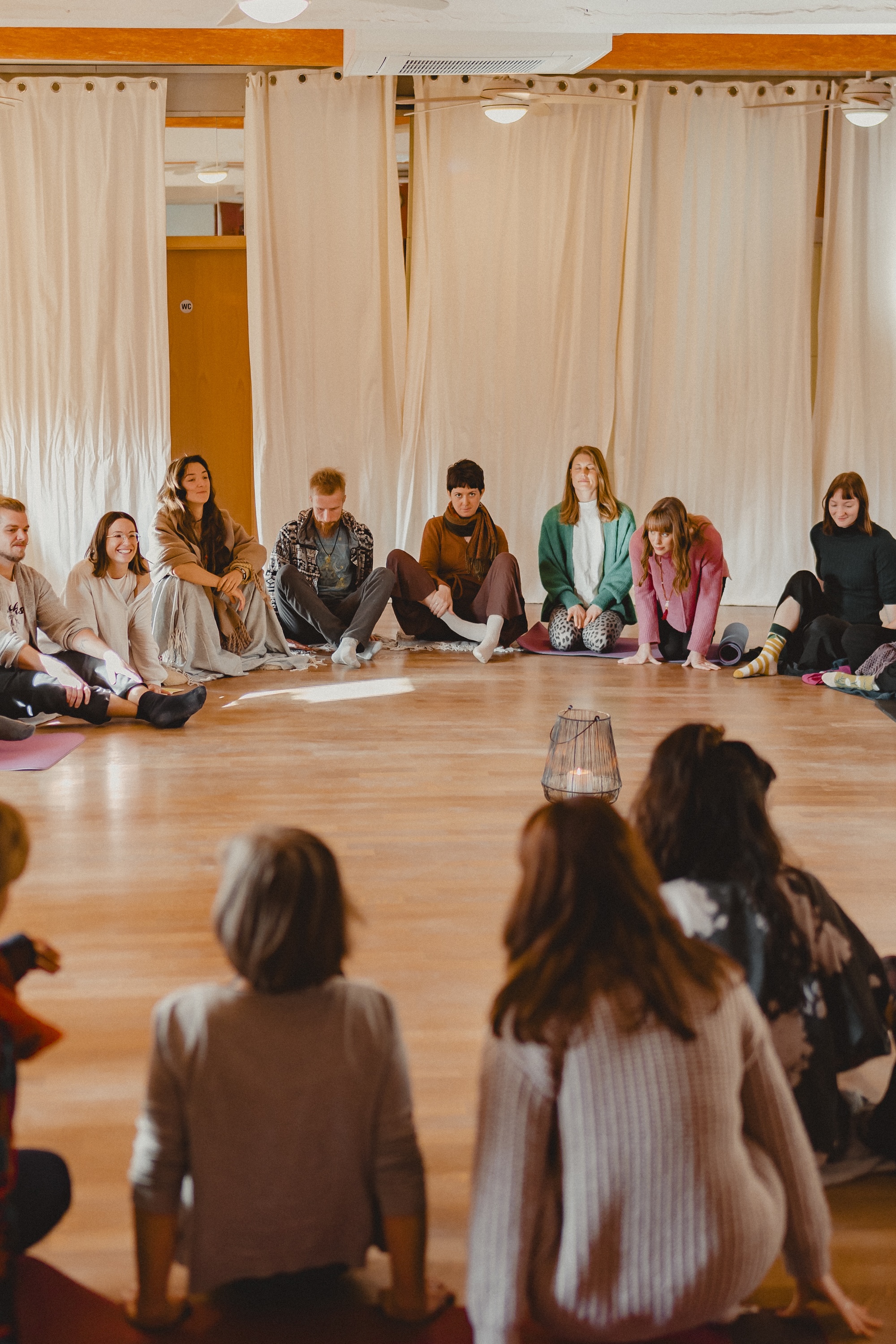 Mehrere Menschen sitzen zusammen im Opening Circle. Man sieht, dass es ein großer Kreis ist.
