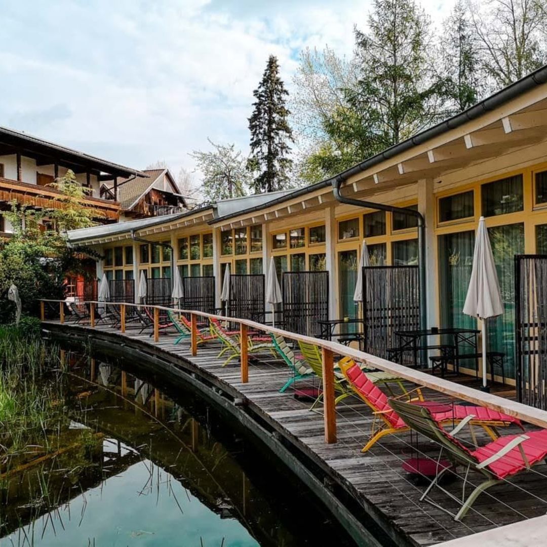 Eine Terrasse mit Liegestühlen entlang eines Gewässers.