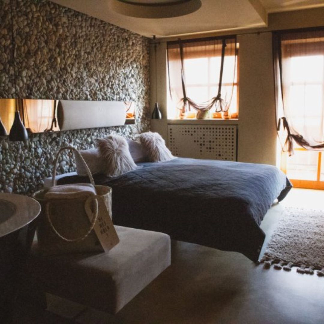 Ein gemütliches Schlafzimmer mit einem Bett und einer Steinwand.