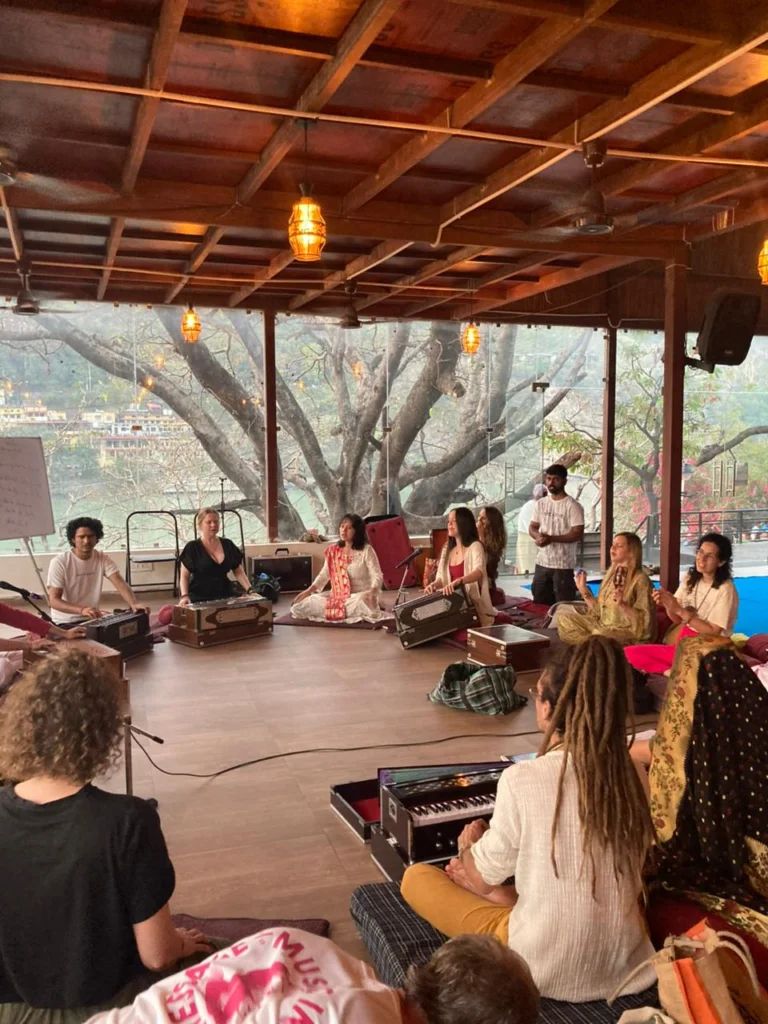 Participants seated in a circle with harmoniums during a group music session.