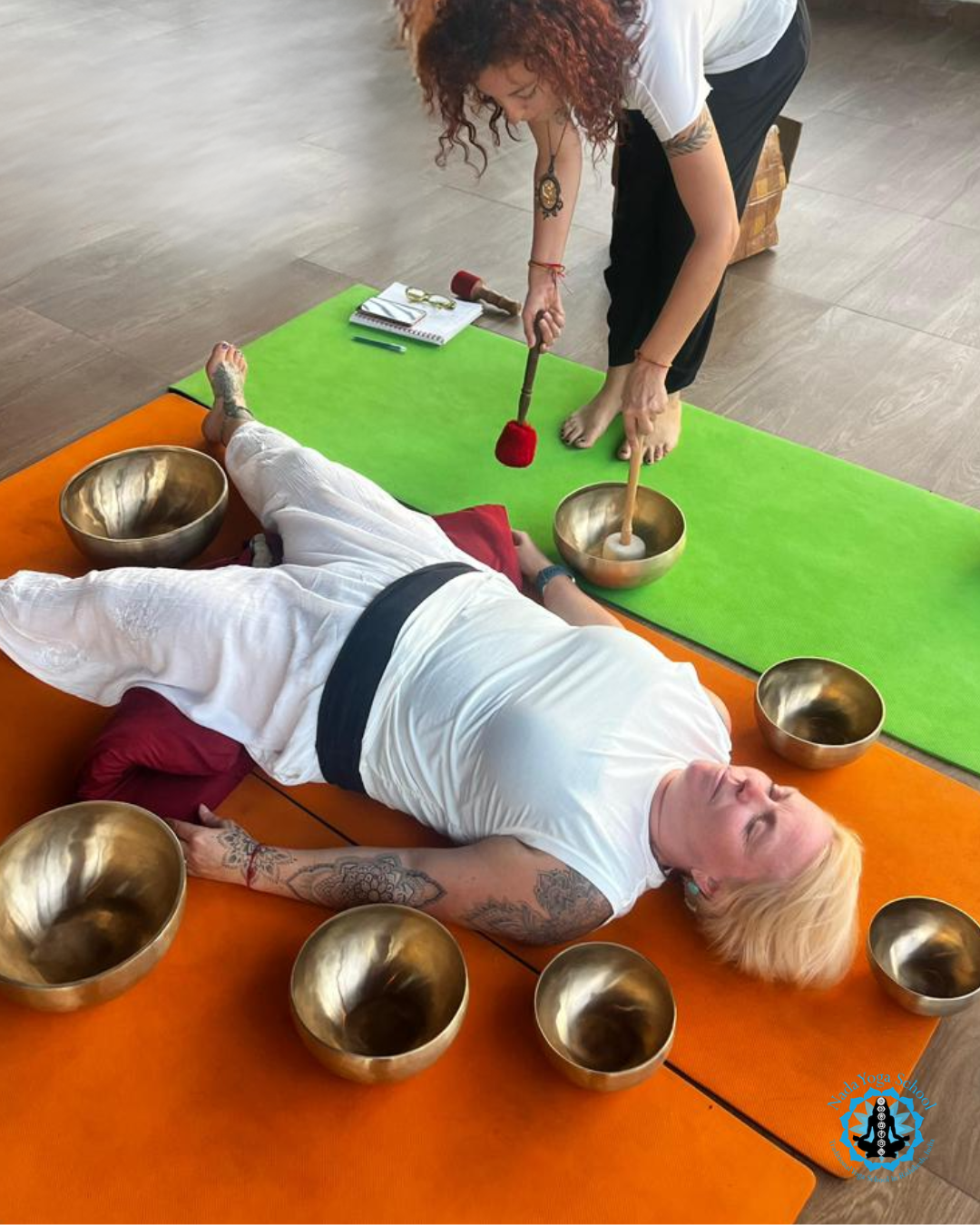 sound healing certification practice where a woman is striking bowls 