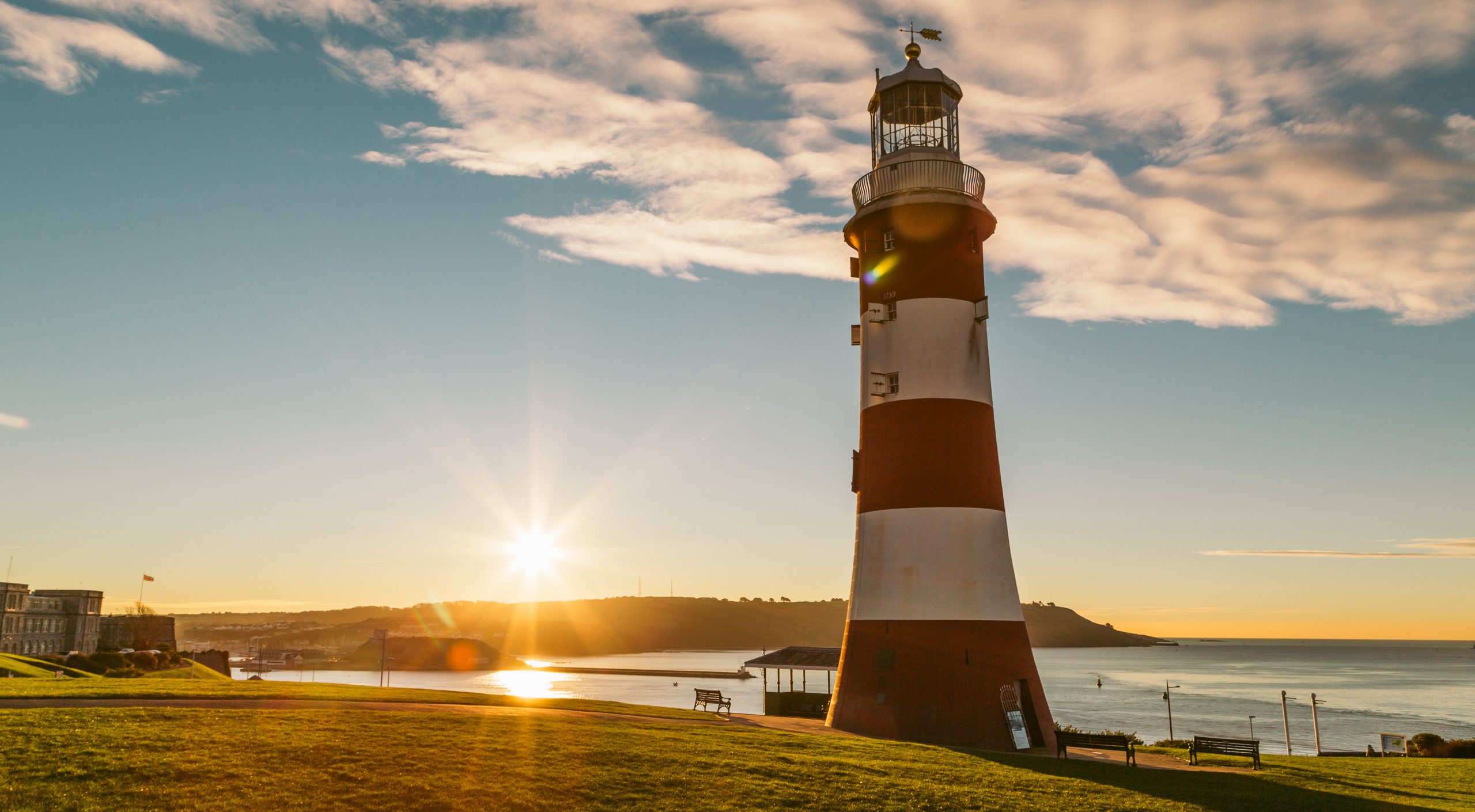 Smeaton's Tower lighthouse on Plymouth Hoe at sunset, overlooking the sea