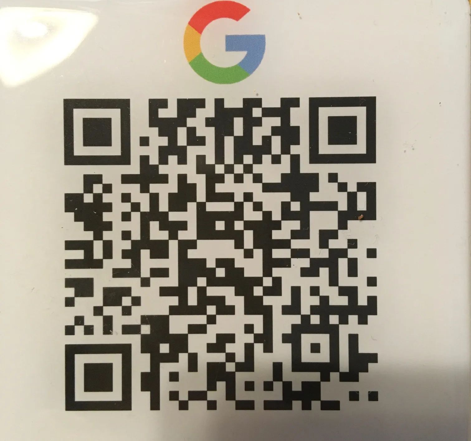 Ein QR-Code auf einer weißen Karte mit einem Google-Logo ist zu sehen.