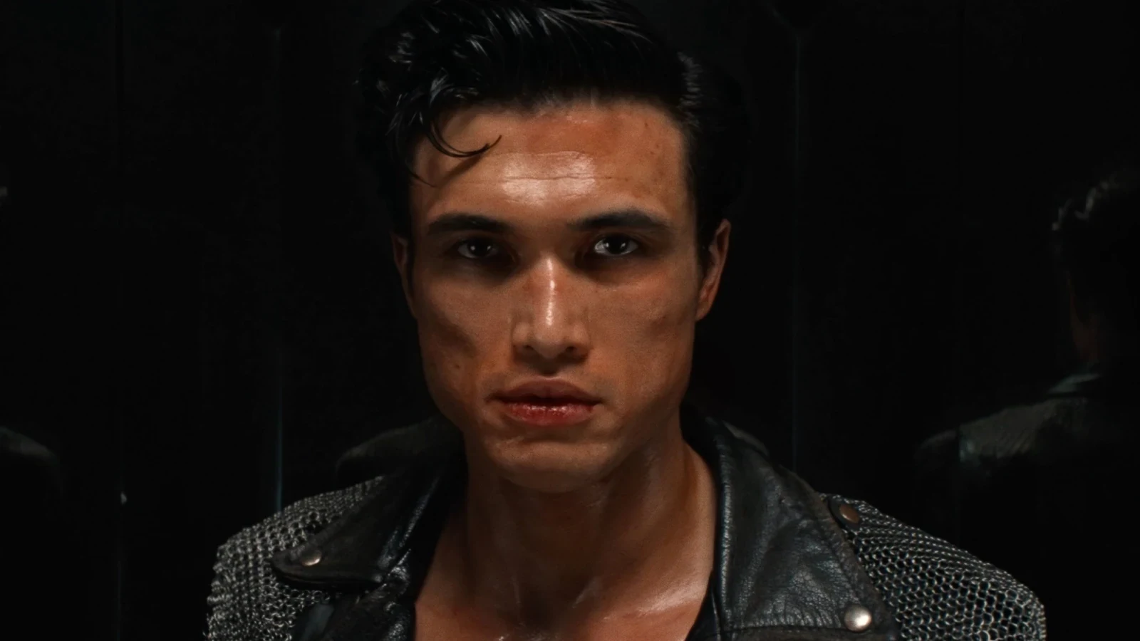 Charles Melton con campera de cuero en primer plano en Su propio infierno