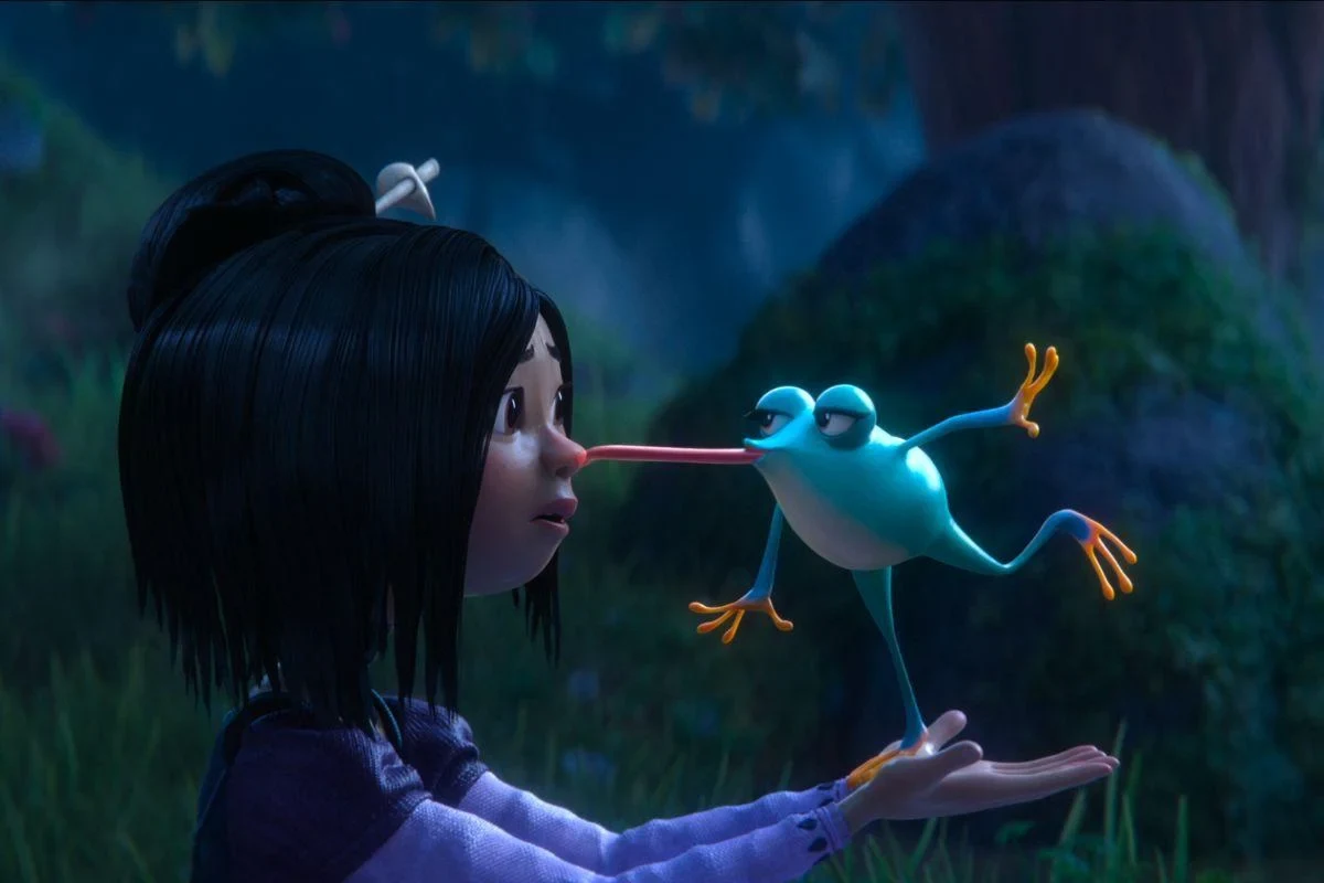 Personaje de cabello negro con una rana en el bosque