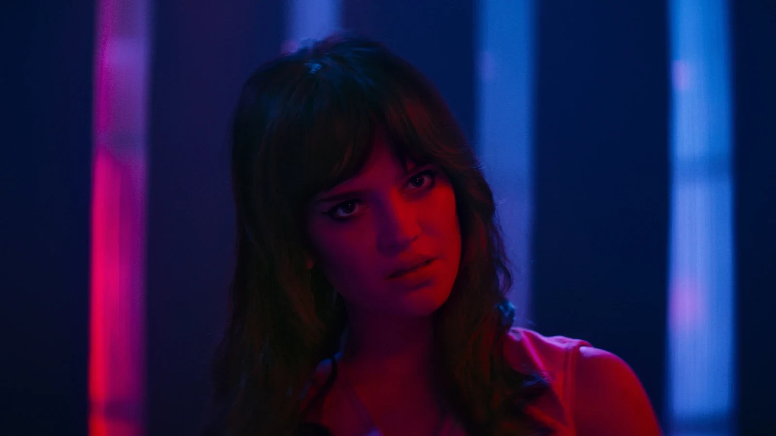 Una de las protagonistas bajo luces de neón rojas y azules en Su propio infierno