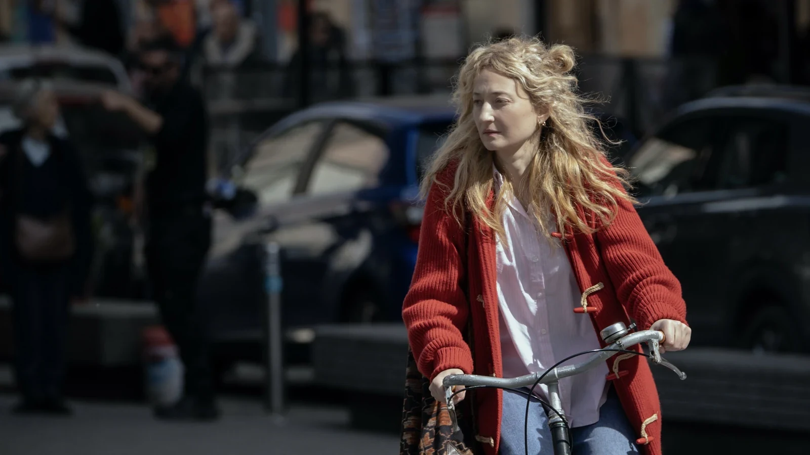 Alba Rohrwacher pedalea en bicicleta con un saco rojo por las calles de Roma