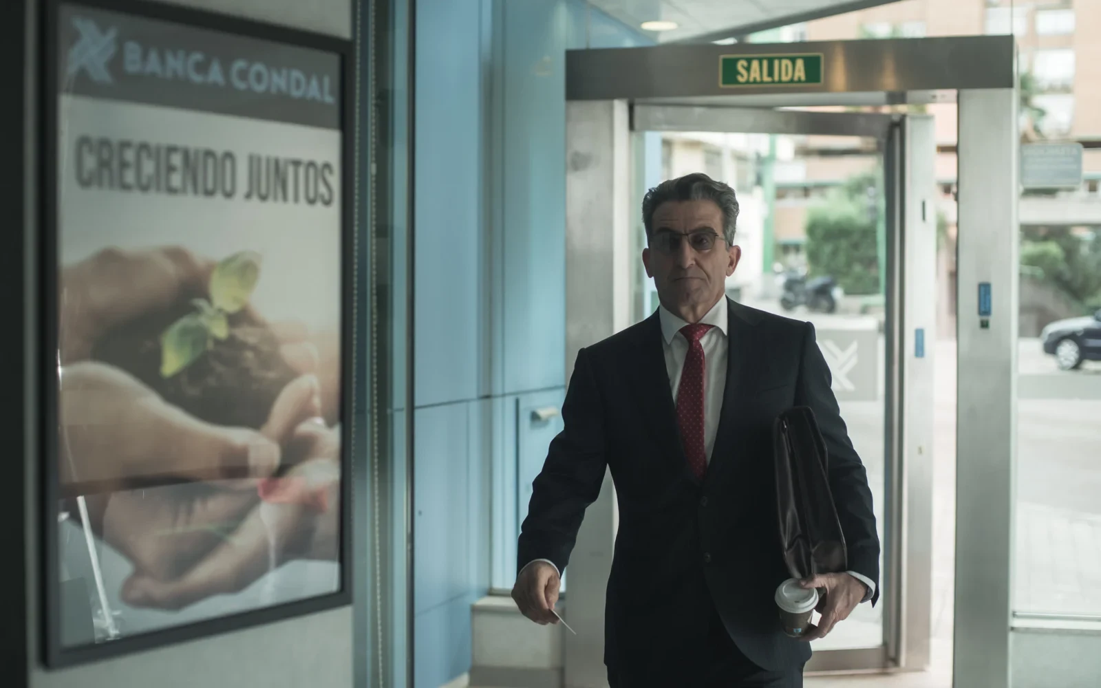 Hombre con maletín sale del banco Banca Condal en Colisión