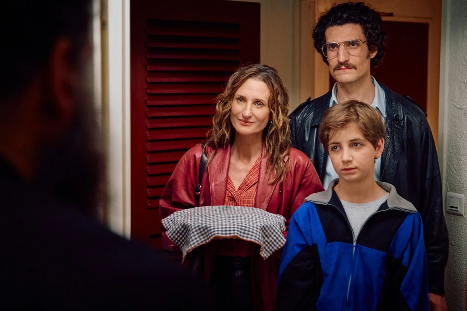 Camille Cottin, Louis Garrel y Simon Boublil de pie en la puerta de un departamento, en Tiempos de ilusión