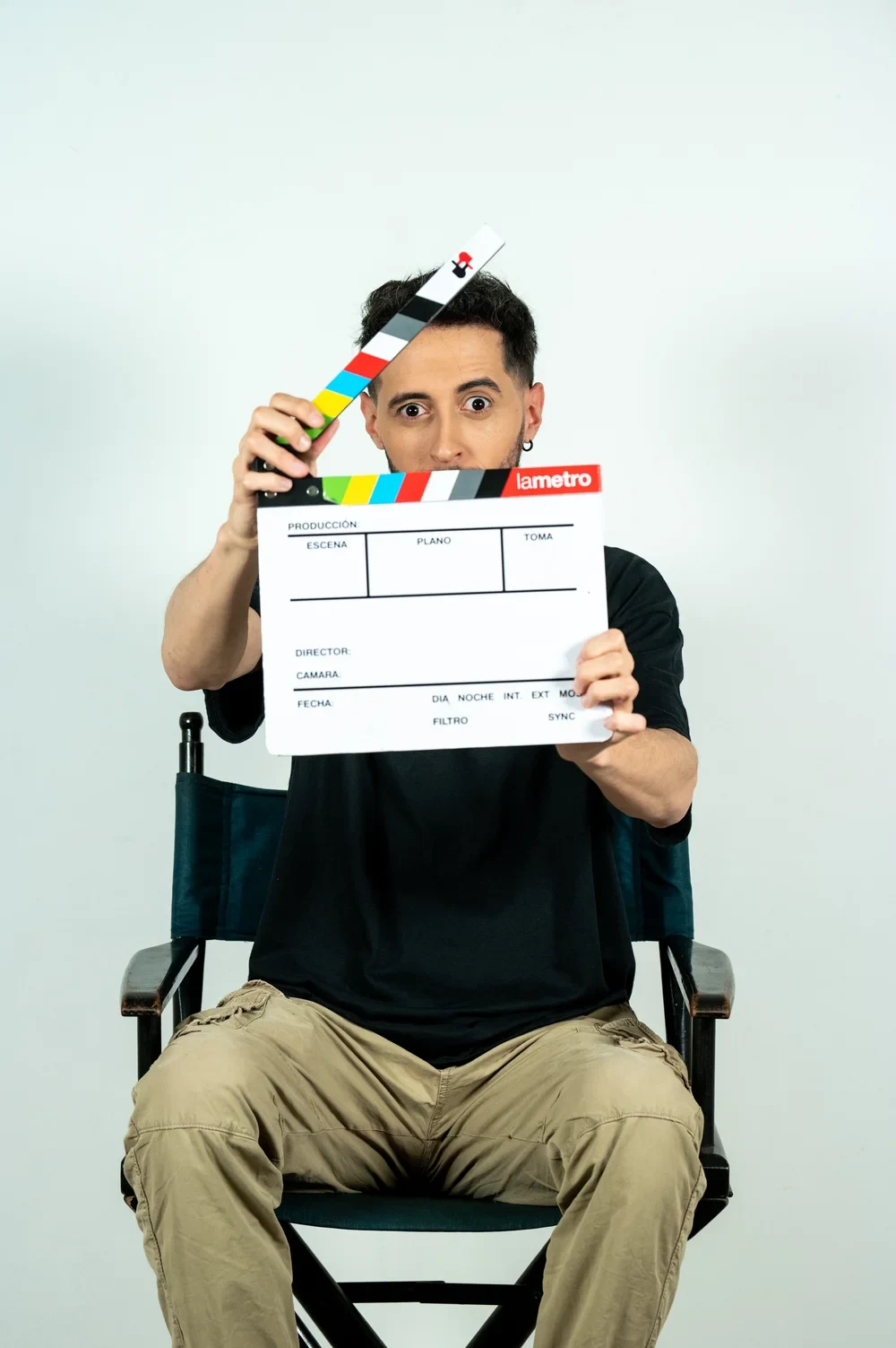Eddie Frari sentado en una silla de director con una claqueta