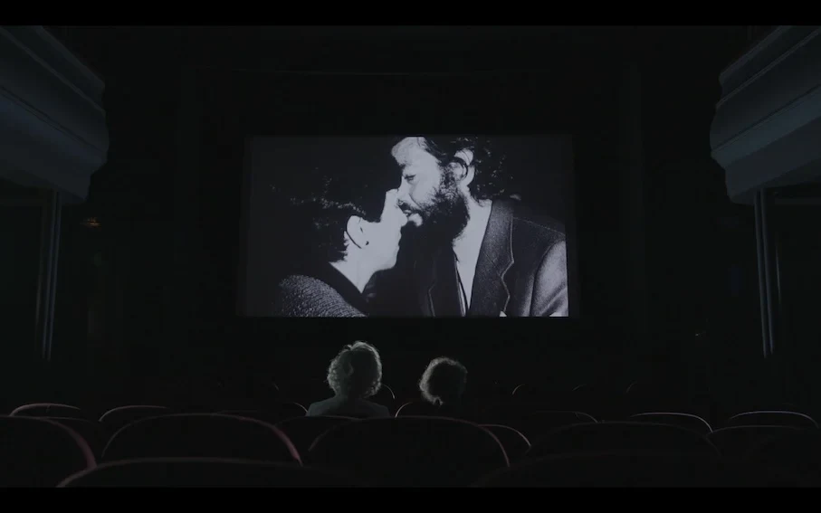 Fotografía en blanco y negro de una pareja proyectada en la pantalla de un cine