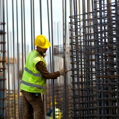 Trabajador de la construcción colocando armaduras de acero en una obra civil
