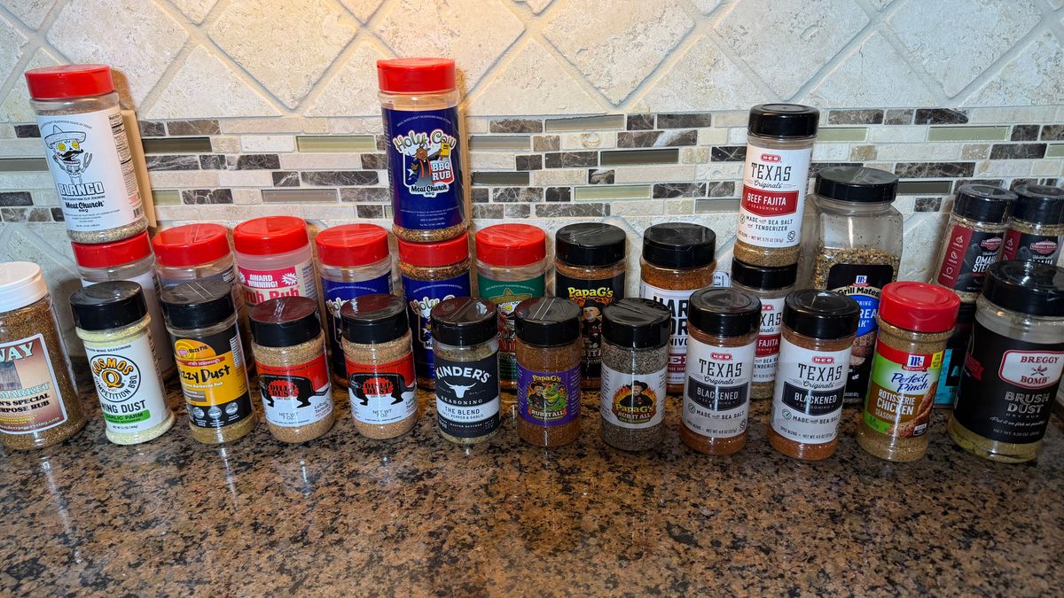 collection of bbq rubs and seasonings organized on a kitchen counter including Meat Church Kinders and Traeger