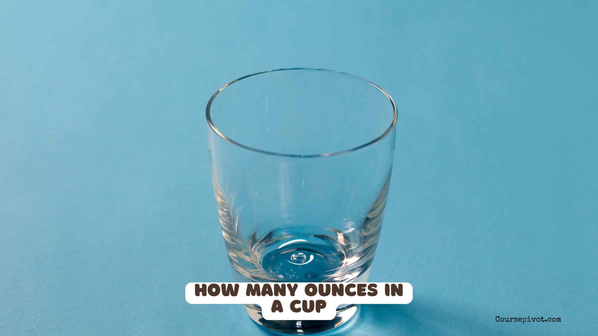 Measuring cup filled with liquid next to measuring spoons on a kitchen counter