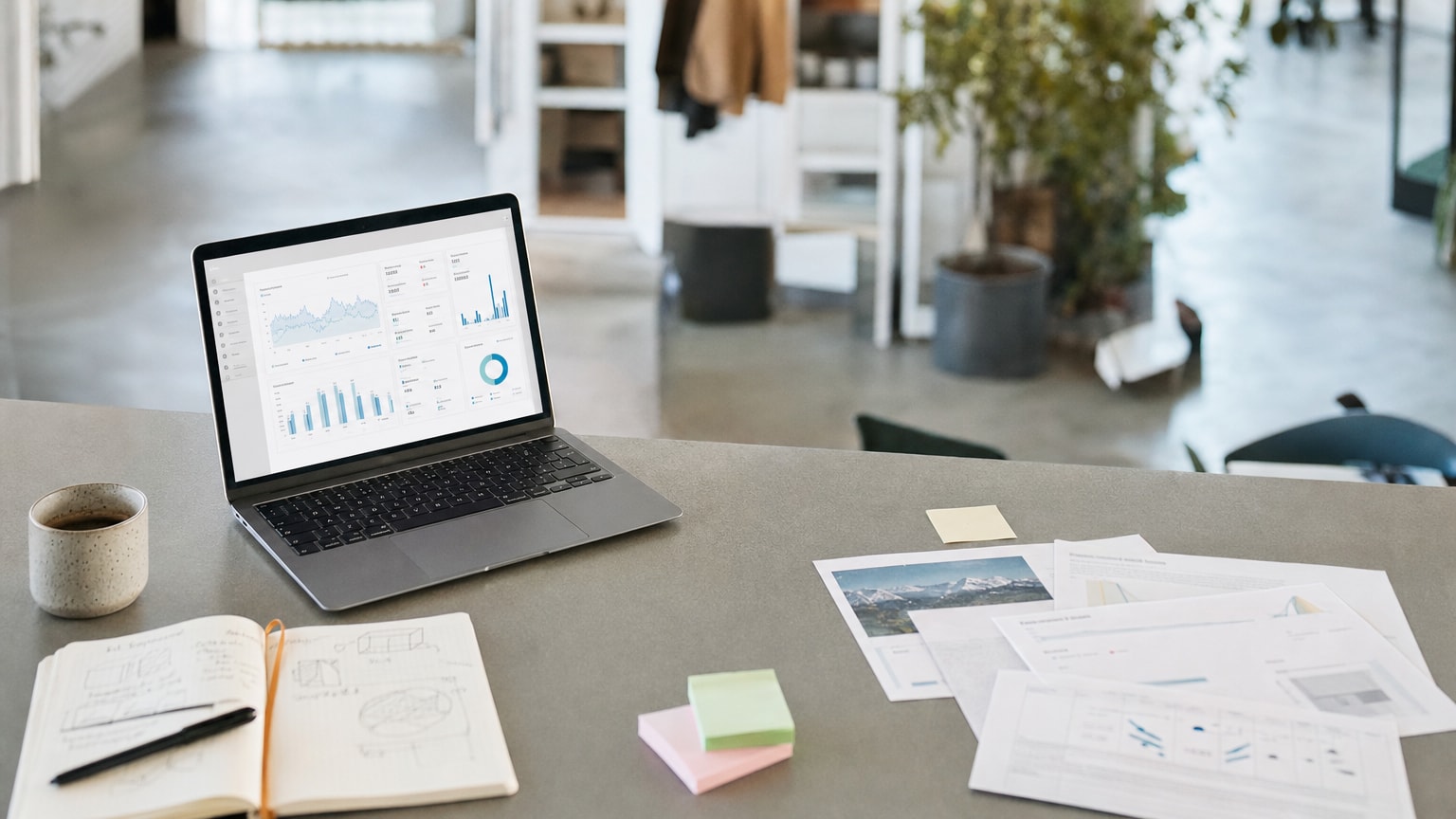 Ein aufgeräumter Schreibtisch mit einem Laptop, auf dem ein übersichtliches Dashboard mit Marketing-Kennzahlen zu sehen ist. Im Hintergrund ein helles, modernes Büro eines kleinen Unternehmens. Warme, professionelle Farbgebung.