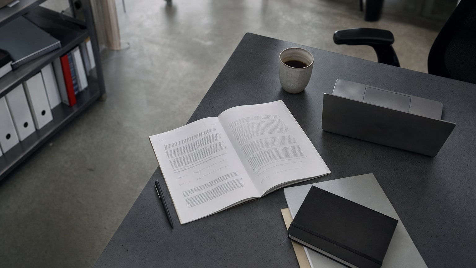 Ein Schreibtisch mit einem aufgeschlagenen Vertragsdokument, daneben ein Laptop und eine Tasse Kaffee – professionelle, ruhige Atmosphäre in einem modernen österreichischen KMU-Büro.