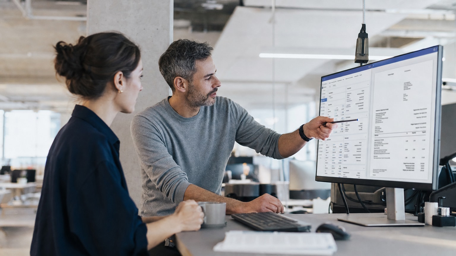 Modernes Büro-Dashboard auf einem Bildschirm, das CRM-Kundendaten und ein automatisch generiertes Angebot nebeneinander zeigt – klare, aufgeräumte Darstellung in hellen Farben.