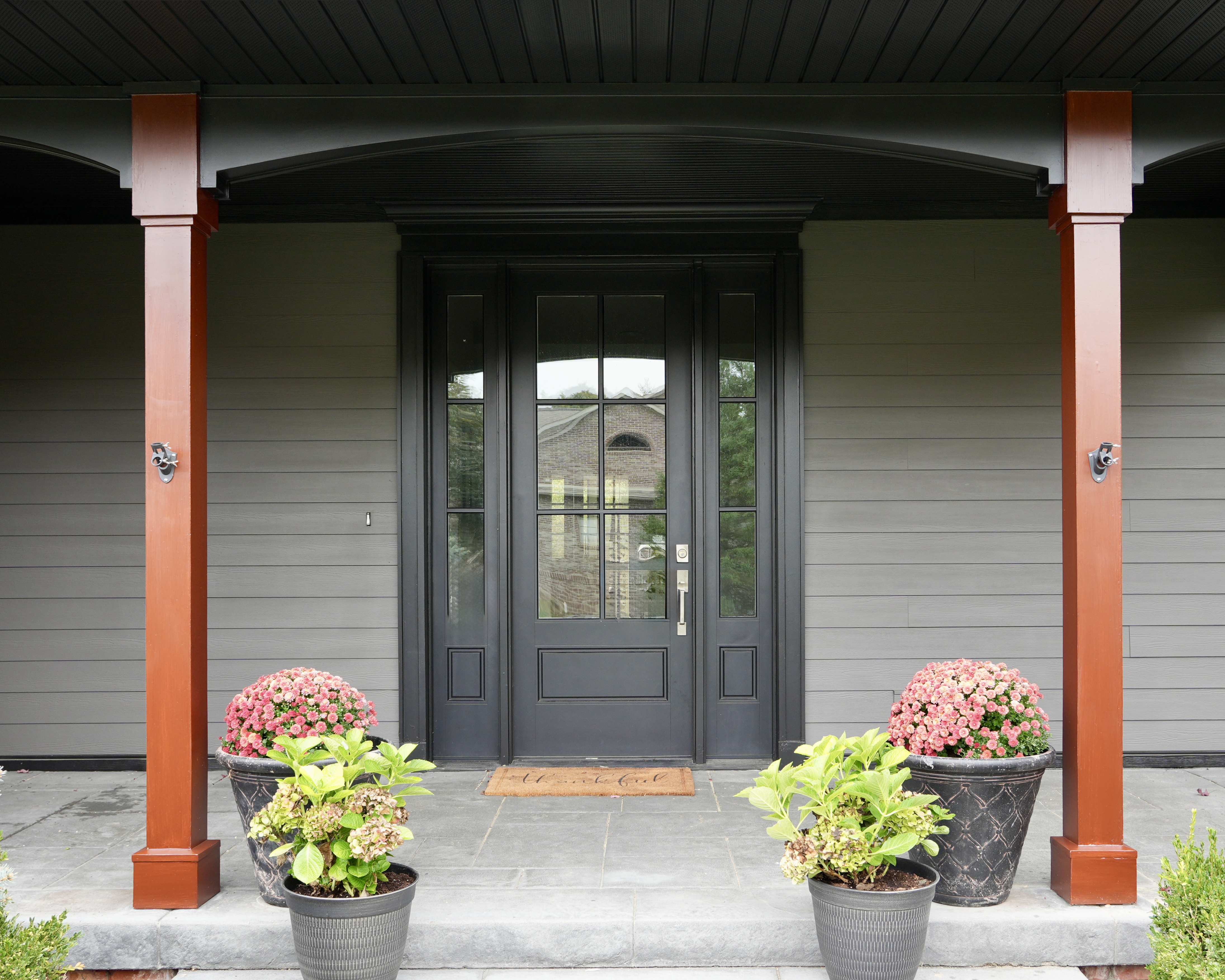 Transform your home exterior with an earthy modern paint palette. Learn how Sherwin Williams Urbane Bronze SW 7048 and Tricorn Black SW 6258 harmonize seamlessly with red brick and wooded landscapes. Discover professional painting tips on color theory, low LRV undertones, and faux stained porch columns for standout curb appeal. Read the full case study at https //craftsmanpainter.com/blog/how-sherwin-williams-urbane-bronze-sw-7048-and-tricorn-black-sw-6258-grounded-th