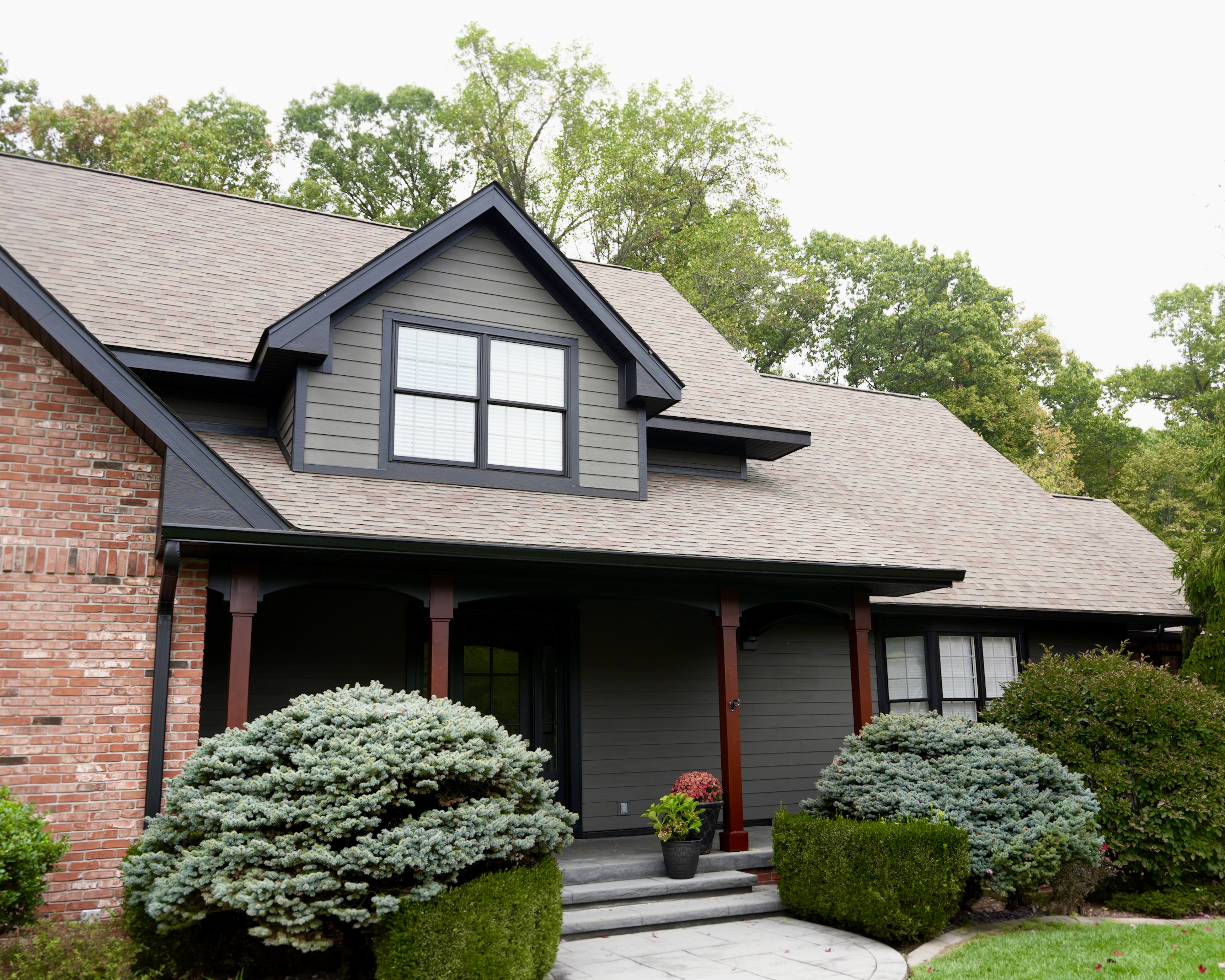 Transform your home exterior with an earthy modern paint palette. Learn how Sherwin Williams Urbane Bronze SW 7048 and Tricorn Black SW 6258 harmonize seamlessly with red brick and wooded landscapes. Discover professional painting tips on color theory, low LRV undertones, and faux stained porch columns for standout curb appeal. Read the full case study at https //craftsmanpainter.com/blog/how-sherwin-williams-urbane-bronze-sw-7048-and-tricorn-black-sw-6258-grounded-th