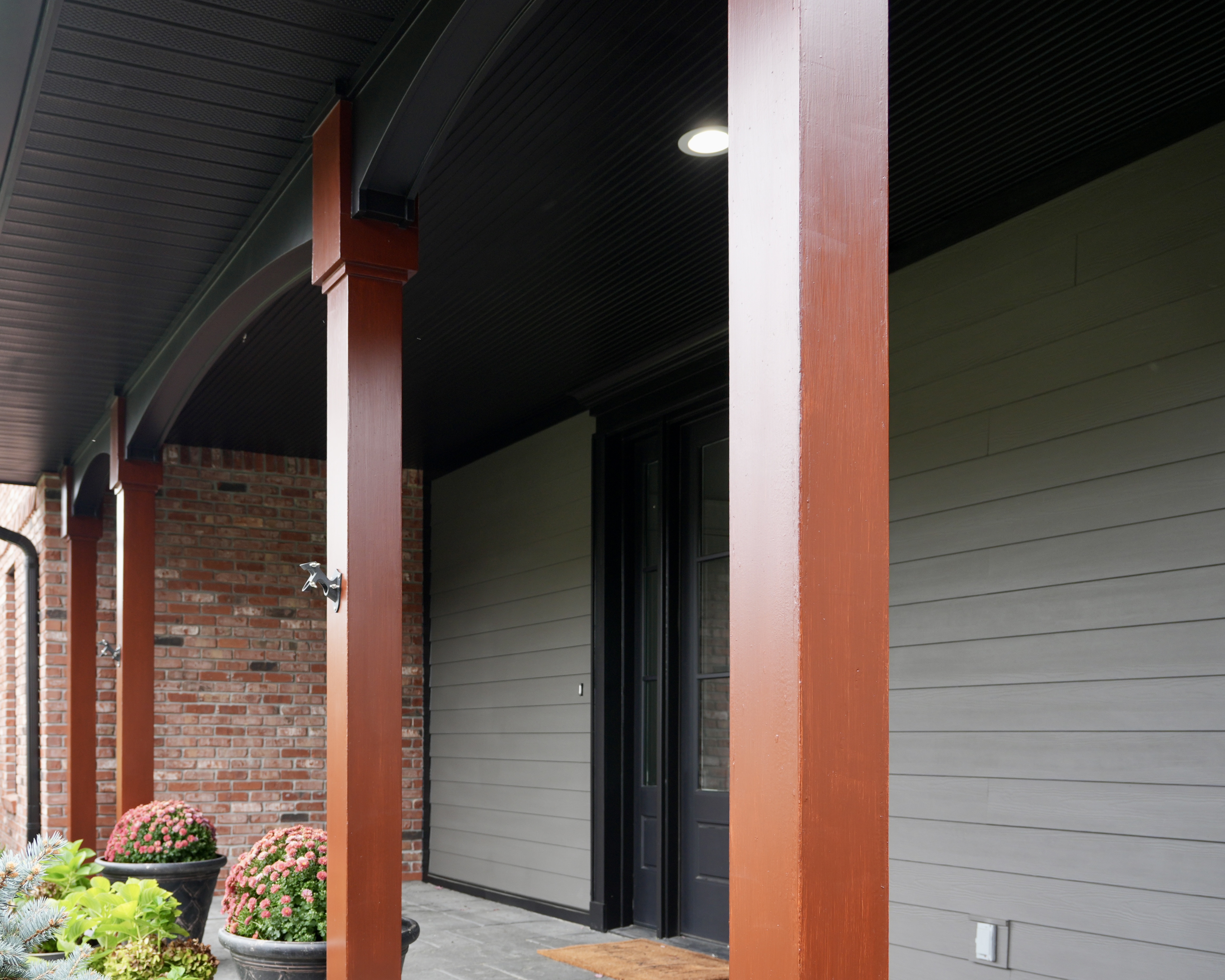 Transform your home exterior with an earthy modern paint palette. Learn how Sherwin Williams Urbane Bronze SW 7048 and Tricorn Black SW 6258 harmonize seamlessly with red brick and wooded landscapes. Discover professional painting tips on color theory, low LRV undertones, and faux stained porch columns for standout curb appeal. Read the full case study at https //craftsmanpainter.com/blog/how-sherwin-williams-urbane-bronze-sw-7048-and-tricorn-black-sw-6258-grounded-th