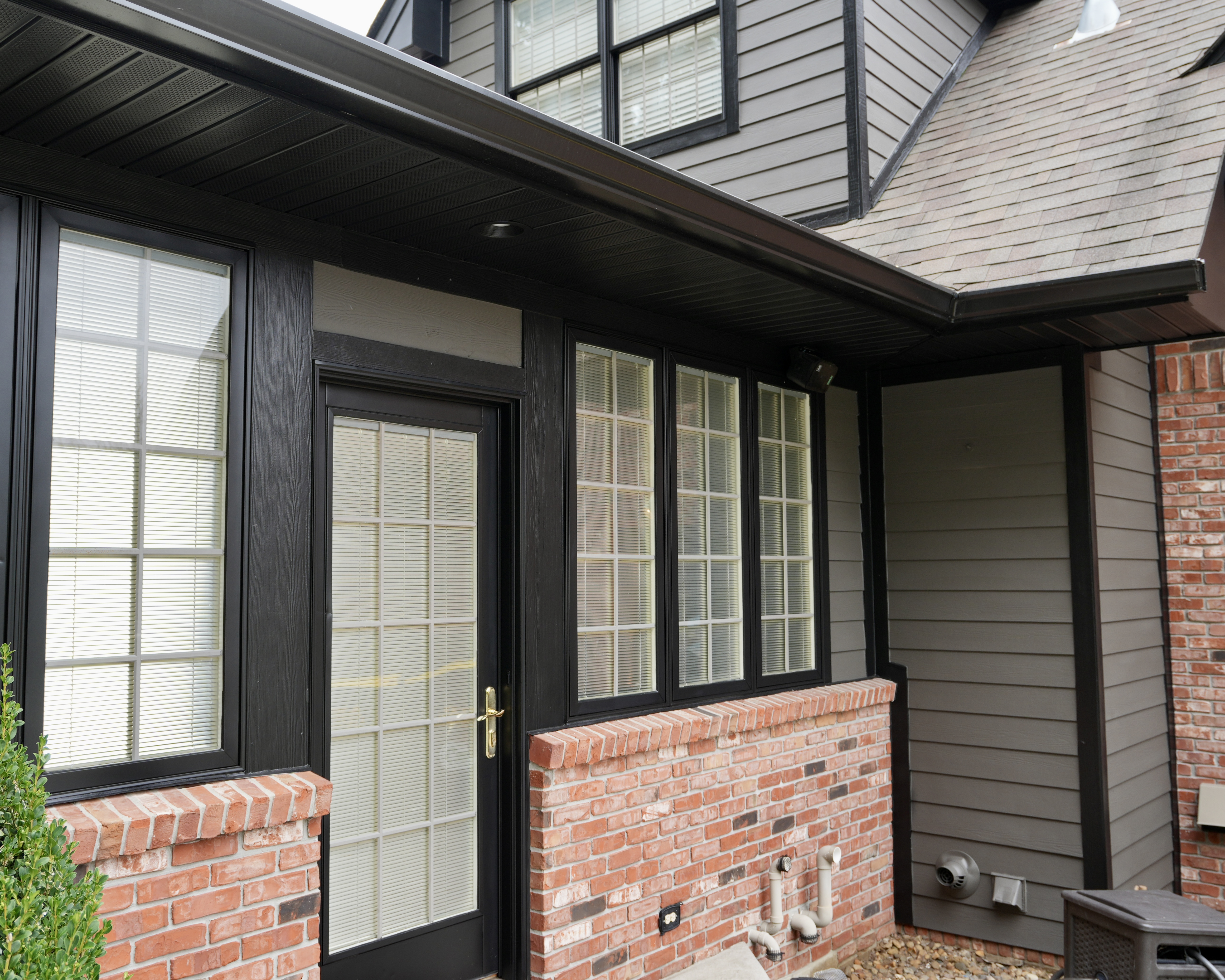 Transform your home exterior with an earthy modern paint palette. Learn how Sherwin Williams Urbane Bronze SW 7048 and Tricorn Black SW 6258 harmonize seamlessly with red brick and wooded landscapes. Discover professional painting tips on color theory, low LRV undertones, and faux stained porch columns for standout curb appeal. Read the full case study at https //craftsmanpainter.com/blog/how-sherwin-williams-urbane-bronze-sw-7048-and-tricorn-black-sw-6258-grounded-th