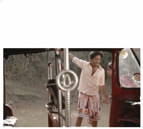 Man hanging from auto rickshaw