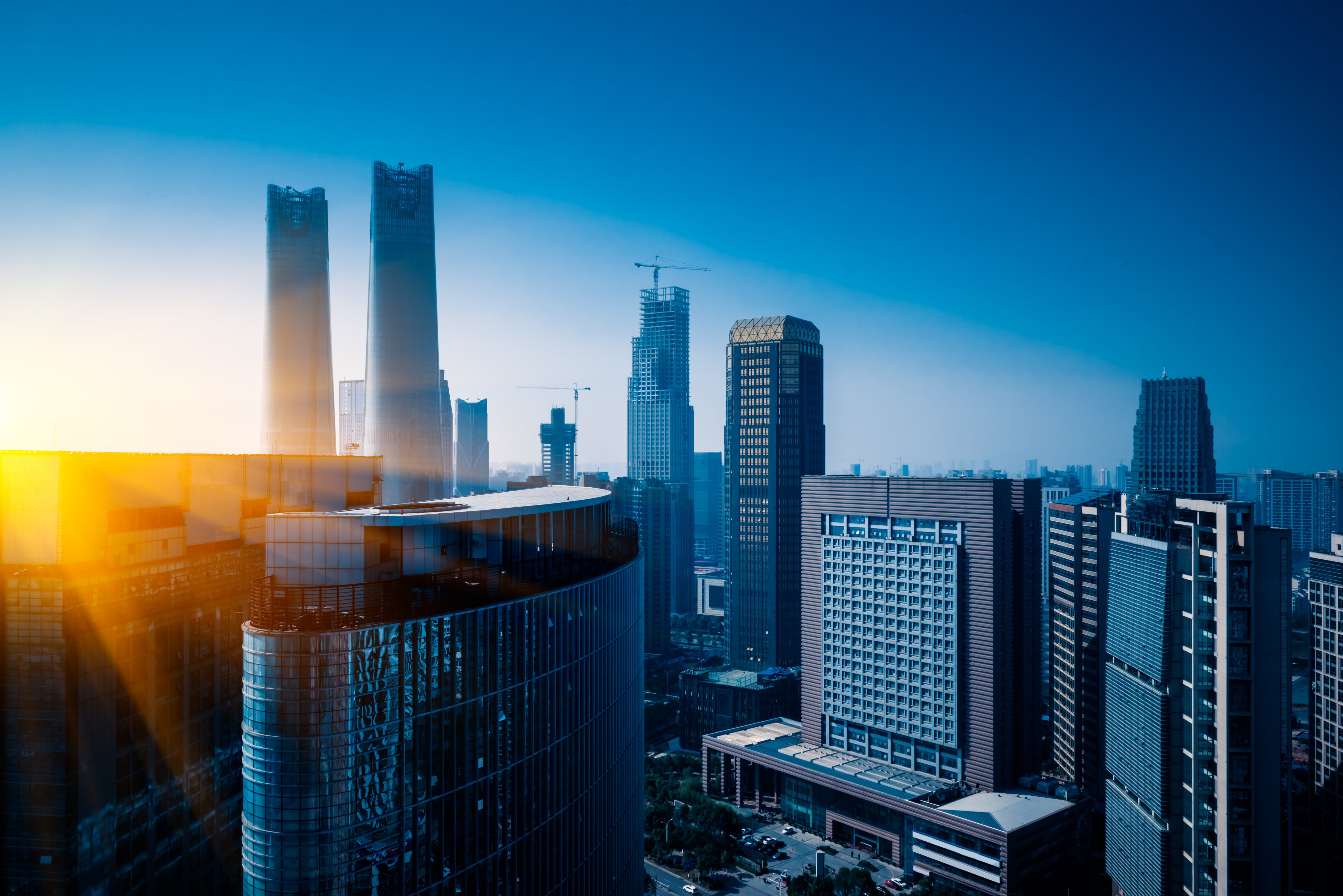 A modern cityscape with a bright sun flare.