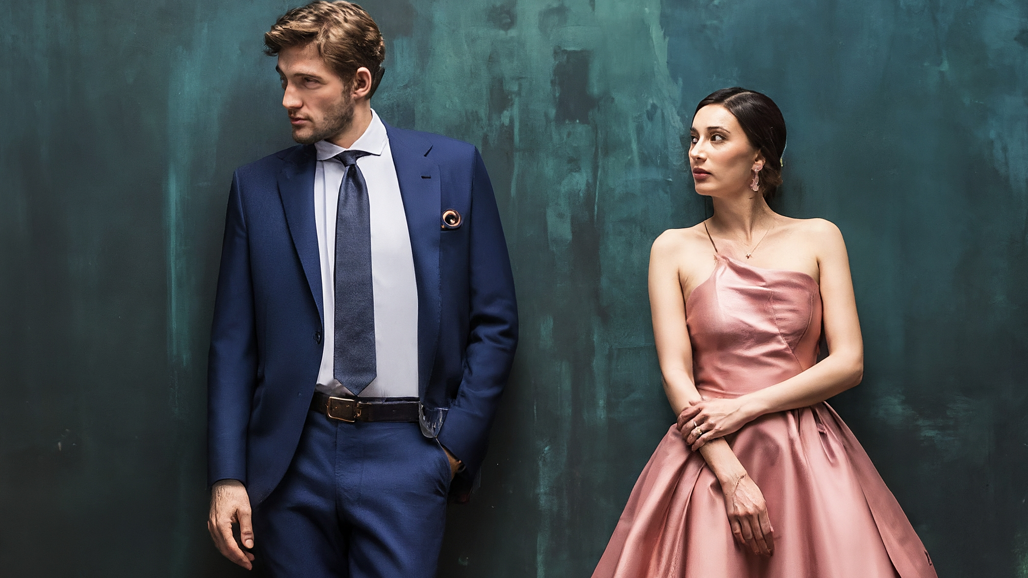 Due lama bianchi stilizzati in abiti eleganti, uno maschio con completo blu e una femmina con vestito rosa. Entrambi hanno un'espressione attenta e analitica. Il lama maschio potrebbe tenere in mano un grafico stilizzato, la femmina uno schermo di dati. Sfondo dai toni freddi e tecnologici. Nessun testo visibile.