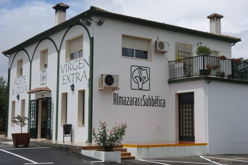 A white two-storey building signed Aceite de Oliva Virgen Extra and Almazaras de la Subbética, the premises of an olive oil cooperative in Córdoba province, southern Spain