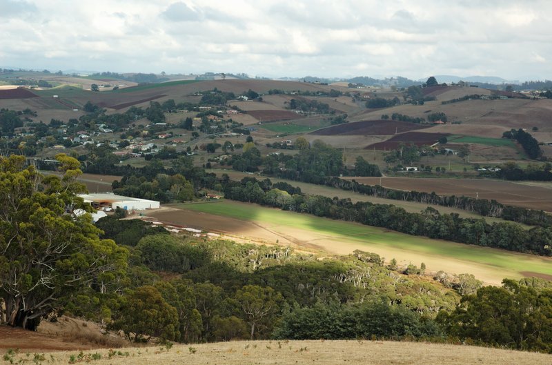The Forth Valley in north-west Tasmania: rolling hills of ploughed red-brown paddocks and green fields around the town of Forth