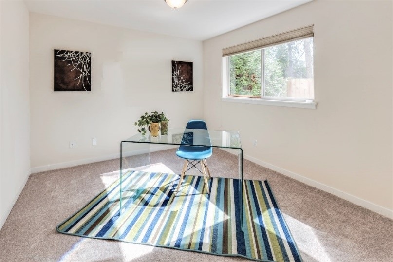 Szoba közepén asztal székkel, háttérben ablak.