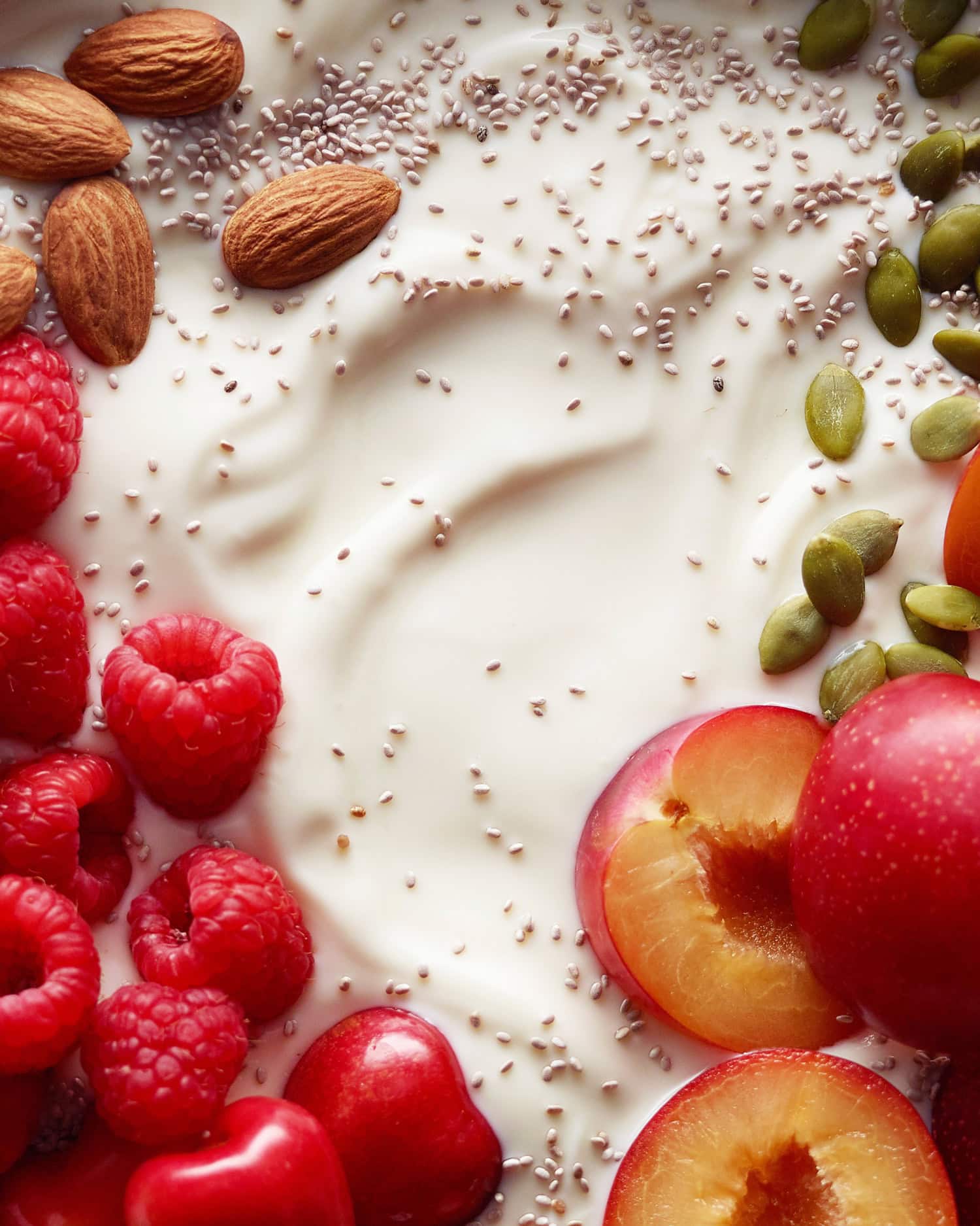 yogurt with chia seeds, almonds, figs, seeds, cherries and raspberries on top. 