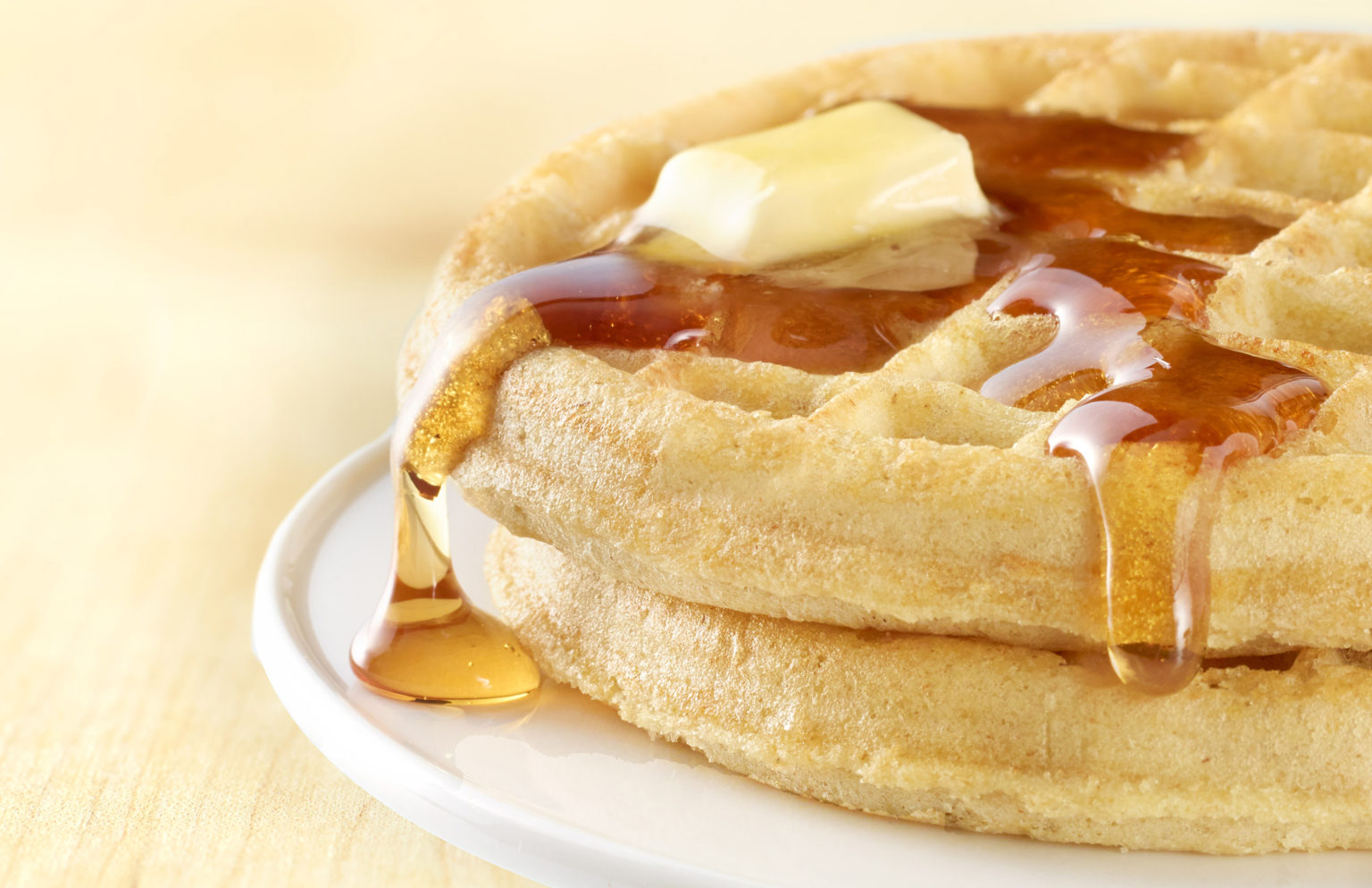 waffle with syrup and butter on white plate