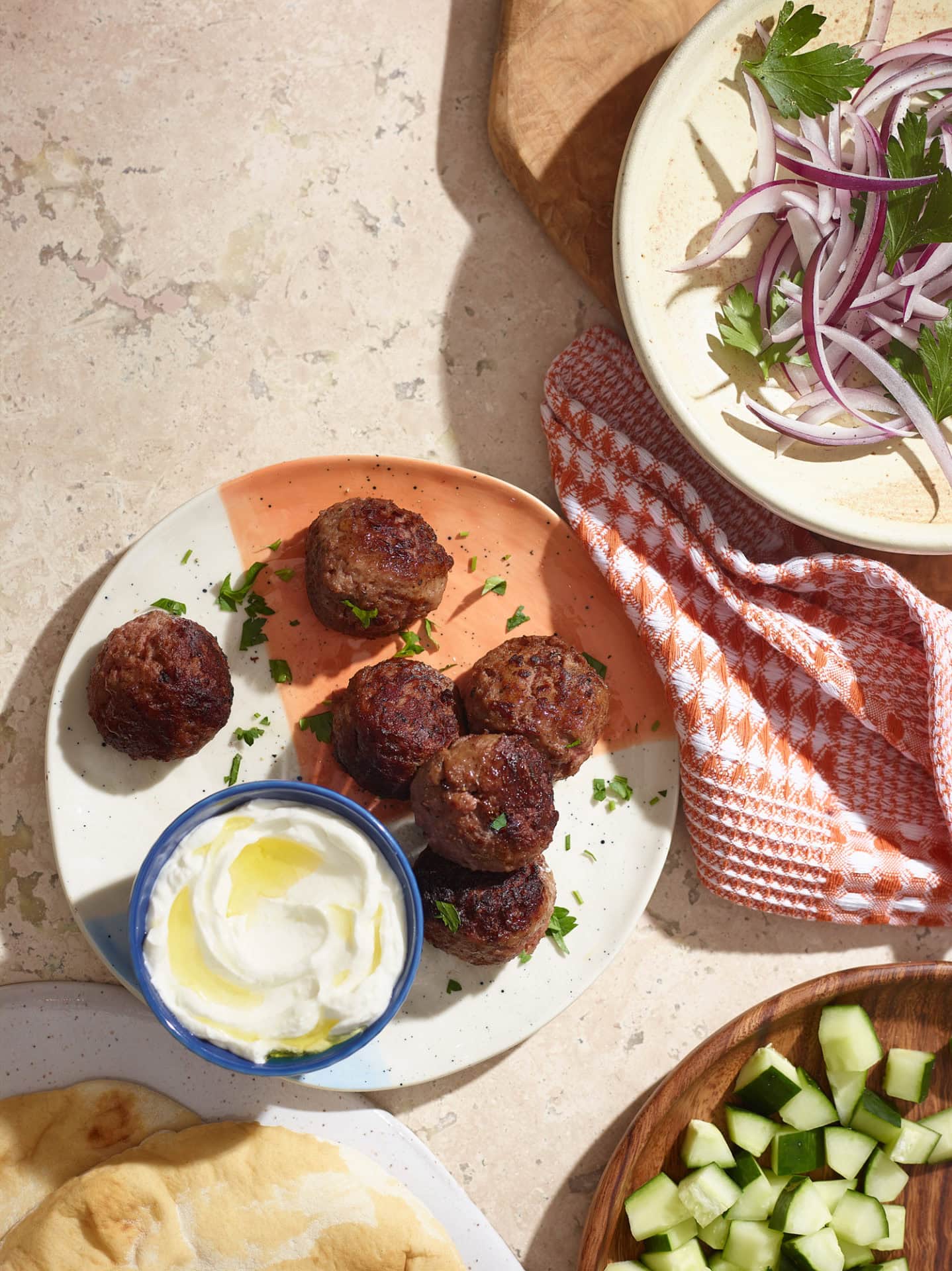 meatballs on plate with white dipping sauce on plate and table with other food products