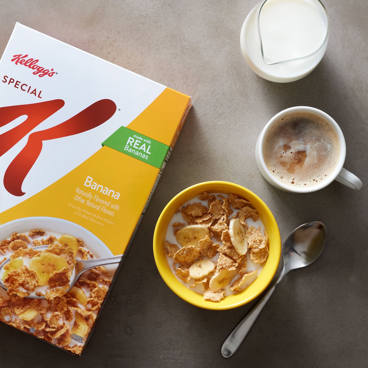 photo of box of kellogs special K cereal box next to bowl of cereal with spoon, coffee cup and glass of milk