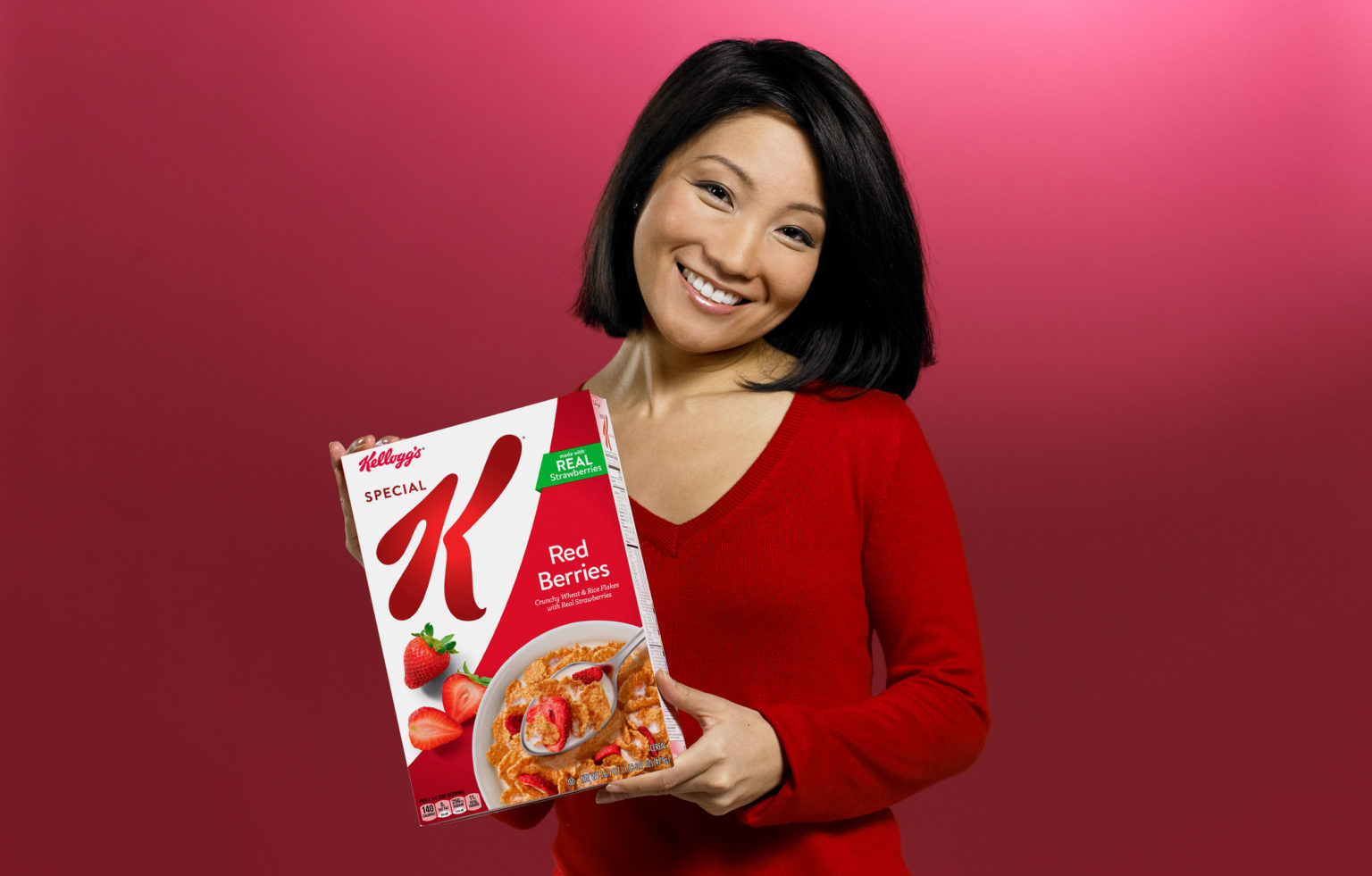 woman with brown hair and red shirt holding a box of special k cereal