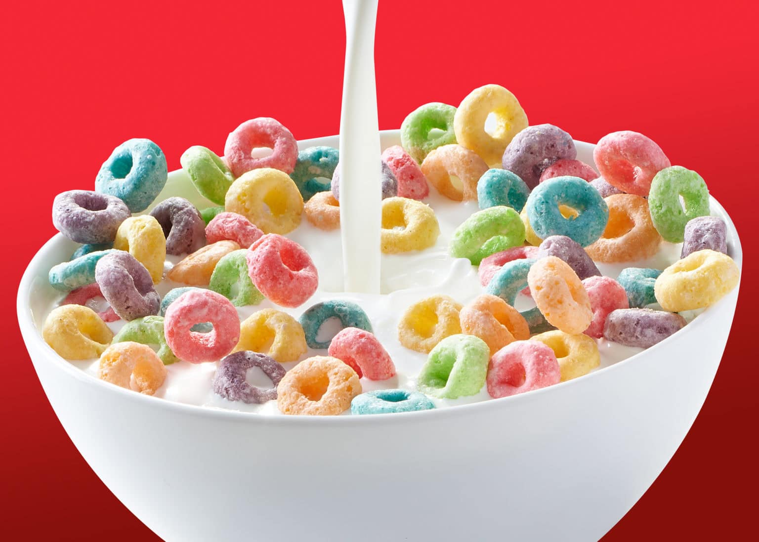 fruitloops in bowl with milk being poured on it