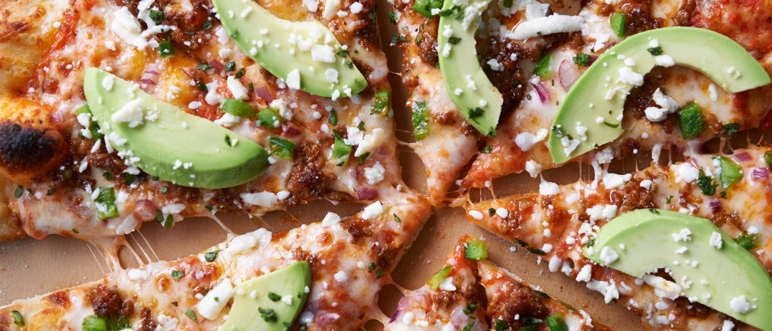 Photo of pizza with avocado on it