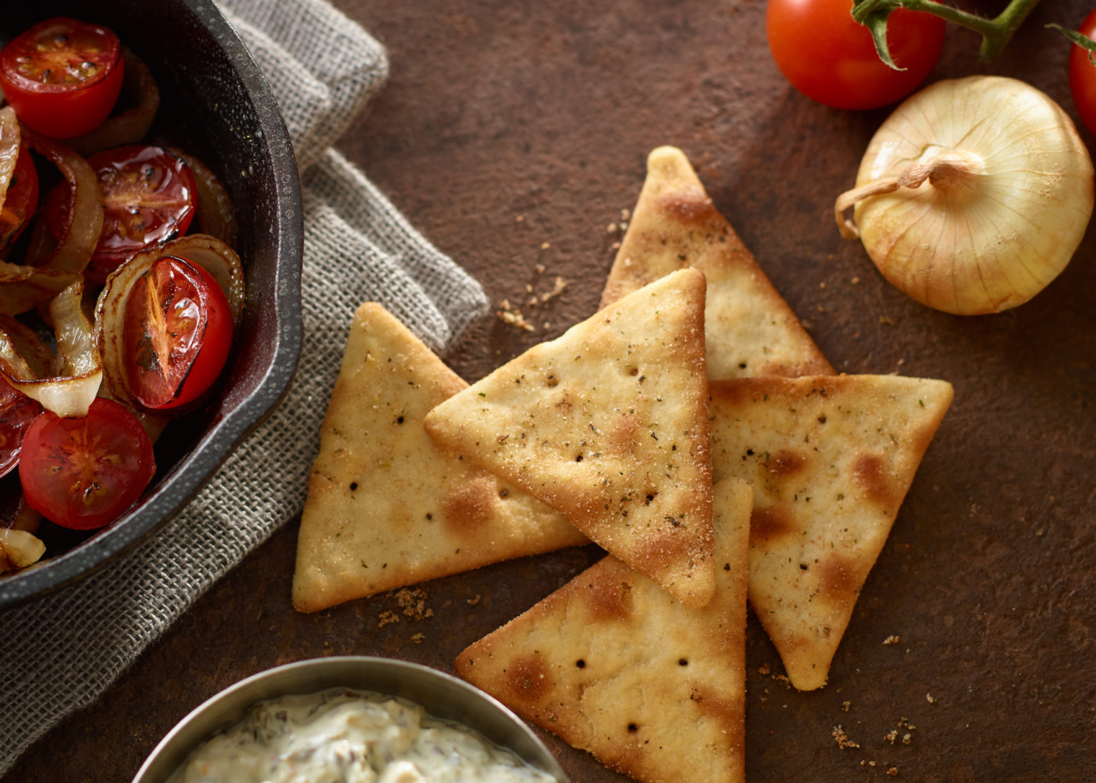 triangular pita crackers on table with ingredients